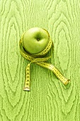 A green apple with a tape measure