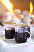 Three cups of mulled wine in front of open fire