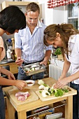 Three young people preparing chicken dish together