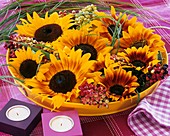 Sonnenblumen mit Schneeballbeeren & Gräsern in gelber Schale