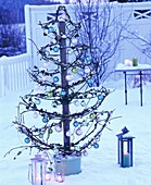 Skeleton Christmas tree with glass baubles & fairy lights outside