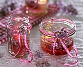 Windlights (candles in screw-top jars), decorated with lilac