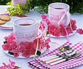 Wreath of pink hydrangeas around mugs of tea