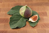 A fig with a piece of fig on a leaf