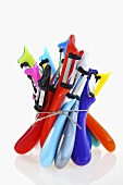 Several coloured vegetable peelers, tied together
