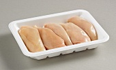 Several chicken breast fillets on plastic tray