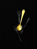Three black spoons and one golden spoon