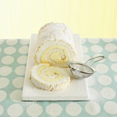 Lemon meringue roulade with icing sugar, a slice cut