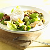 Salad with poached egg, anchovies, chicken and olives
