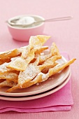 Faworki (Polish fried pastries) with icing sugar