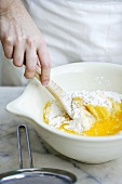 Making muffin mixture: mixing flour with egg yolks