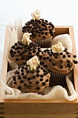 Chocolate cupcakes with marzipan roses in wooden box
