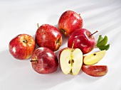 Mehrere rote Äpfel (ganz, halbiert und Schnitze)