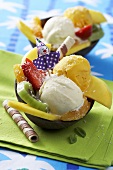 Tropical ice cream sundaes with orange ice cream, coconut ice cream & fruit