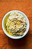 Hummus with olive oil in pale blue dish (overhead view)