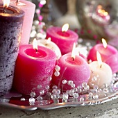 Weihnachtsdeko: Brennende Kerzen und Perlenkette