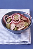 Sausage salad with onions and gherkins
