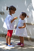 Two little girls with a glass of juice