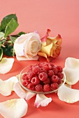 Raspberries with rose petals and roses