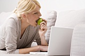 Blond woman biting into an apple