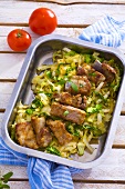 Roasted pork ribs with cabbage in roasting tin