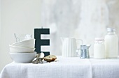 Crockery on table, letter E in background