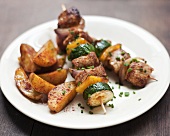 Meat, courgette and pepper kebabs with potato wedges