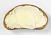 A slice of buttered brown bread (made with wheat and rye flour)