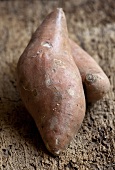 Two sweet potatoes on wooden background