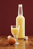Advocaat in glass and bottle, egg with feather