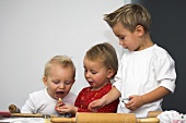 Three children baking biscuits