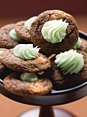 A bowl of chocolate macarooms with green cream