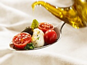 Drizzling tomatoes, mozzarella and basil with olive oil