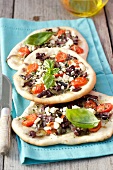 Flatbread topped with vegetables, anchovies and feta cheese