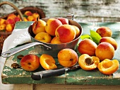 Apricots in pan, on wooden table and in basket