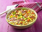 Vegetable soup with pasta and sliced sausage