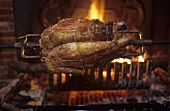 A whole chicken being spit-roasted over an open fire, Provence