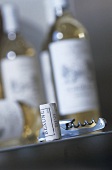 White wine cork & corkscrew in front of bottles of white wine