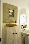 Foto in überbreitem Holzrahmen über einem Badezimmer-Schränkchen aus gebürstetem, lasierten Holz