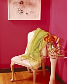 Corner of magenta room with lime green cloth on chair and side table with clear acrylic top