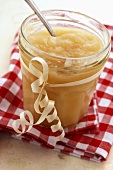Apple sauce in a jar on a checked cloth