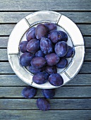 A plate of fresh plums, seen from above