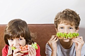 Two children eating sandwiches