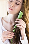 A woman wrapping her hair around an aloe vera leaf