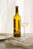 A glass and a bottle of white wine
