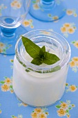 A jar of yogurt with mint