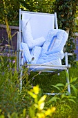 Blue deck chair in a garden with pillows which spell 'LOVE'