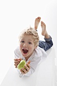 A little boy holding a half-eaten apple