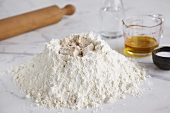 Baking ingredients (flour, yeast, salt, water, oil) and rolling pin