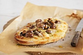 Minipizza mit Champignons und Pecorino auf Backpapier